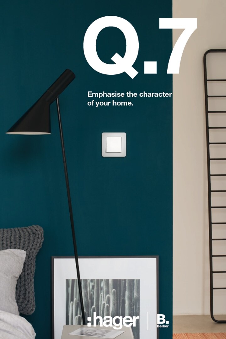 Modern interior with teal wall, stylish floor lamp, and white Hager switch from Berker Q. series