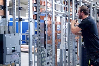 Technician working on electrical switchgear in an industrial setting