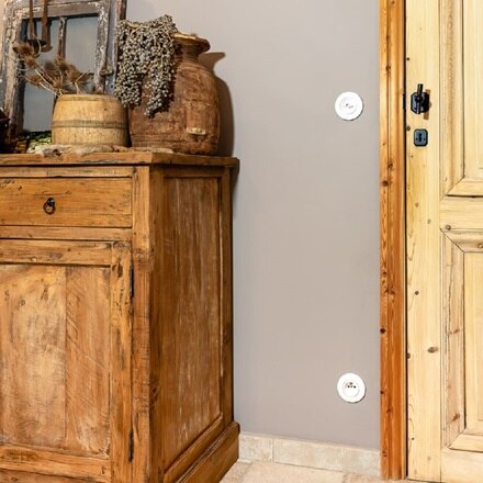 Witte schakelaar en stopcontact Serie 1930 retro aan muur in landelijke woonkamer