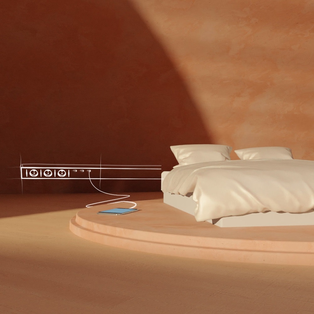 bed met aan de muur een kabelgoot met stopcontacten getekend