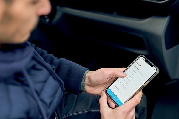 Persoon navigeert op smartphone door een ondersteuningsmenu met opties zoals FAQ, Support en Mijn projecten.