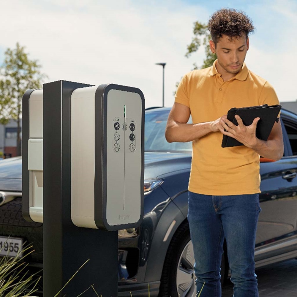 man met tablet en laadpaal witty op parking