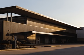 Modern industrial building facade with geometric architecture in sunset lighting