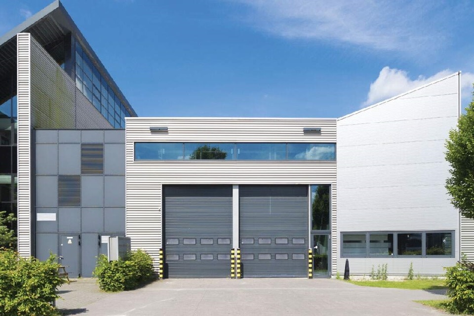 Modern industrial building with large garage doors and glass facade
