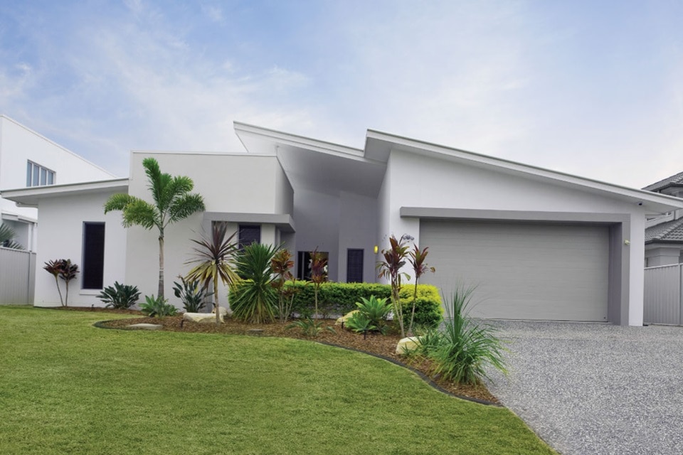 Modern single-story house with double garage and landscaped garden