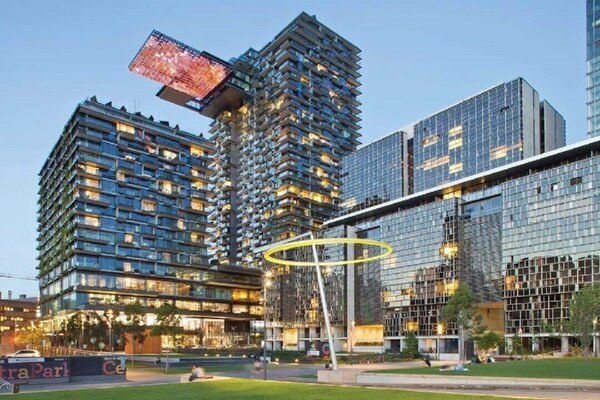 Modern urban architecture with illuminated buildings at dusk and public green space