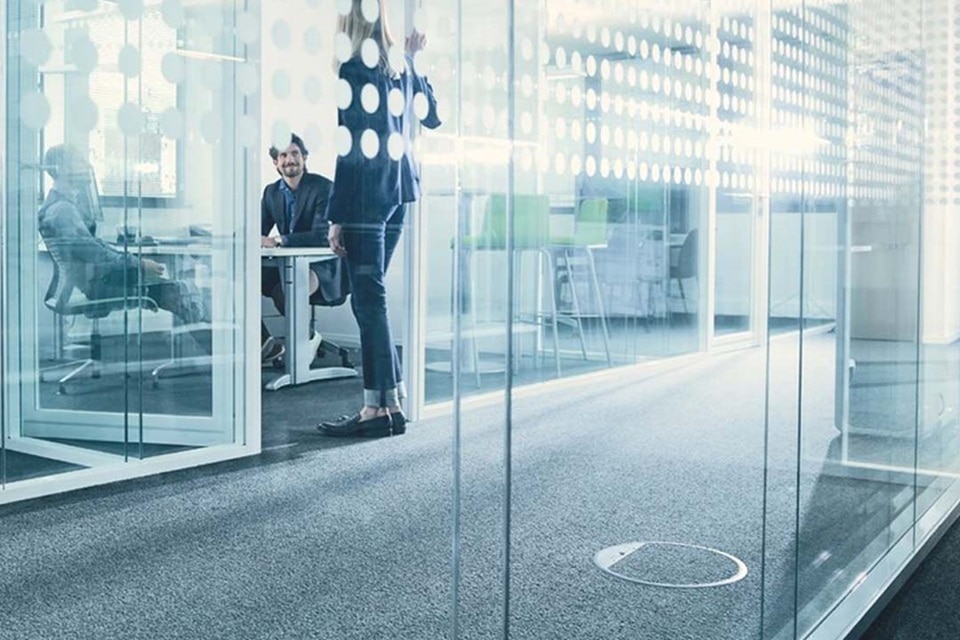 Nowoczesne środowisko biurowe z pracownikami pracującymi za przeszklonymi ściankami