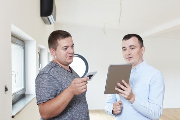 Dwóch mężczyzn korzystających z funkcji doboru osprzętu elektroinstalacyjnego w darmowej aplikacji Hager Ready na tablecie