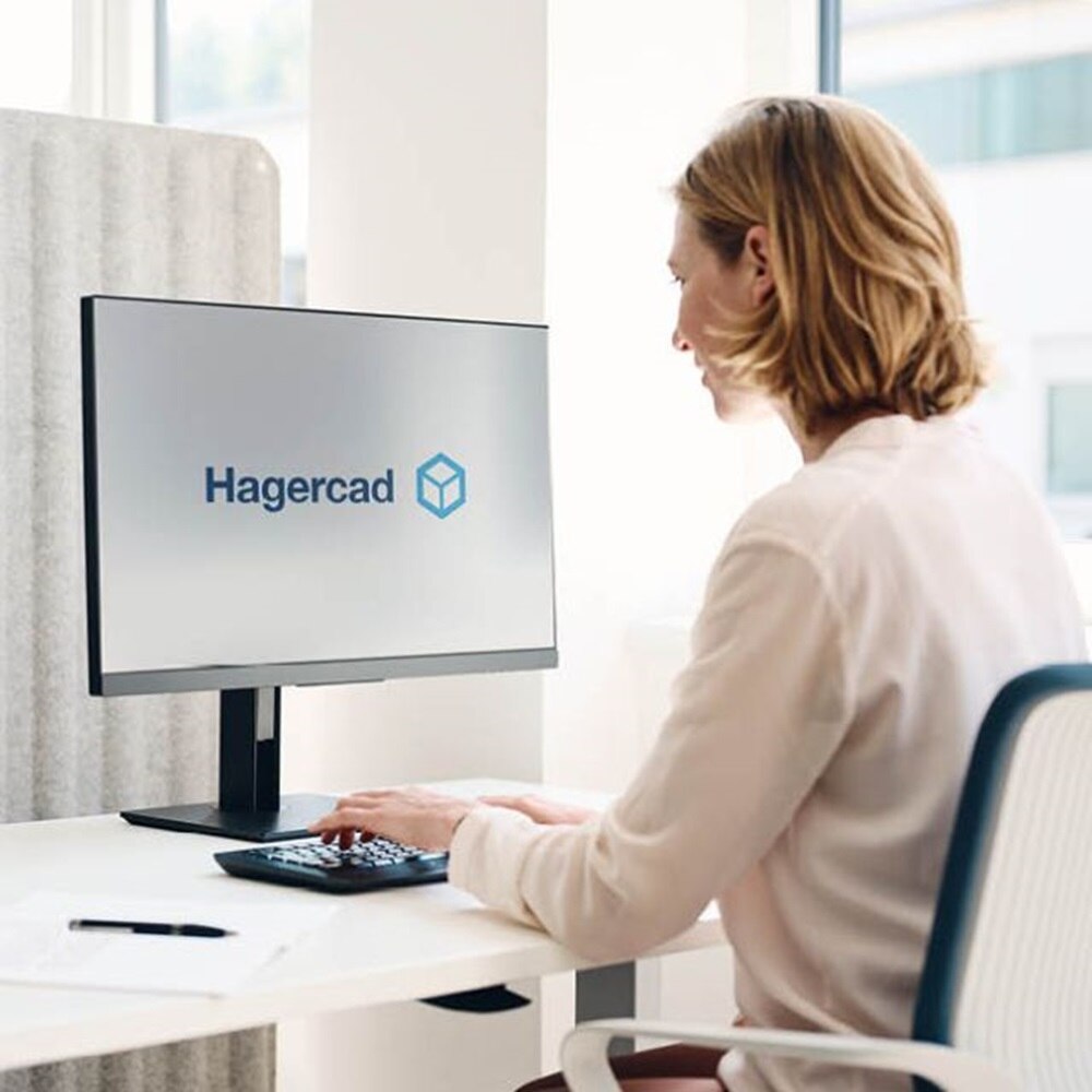 Kobieta siedząca przy komputerze, na monitorze logotyp programu do projektowania Hagercad