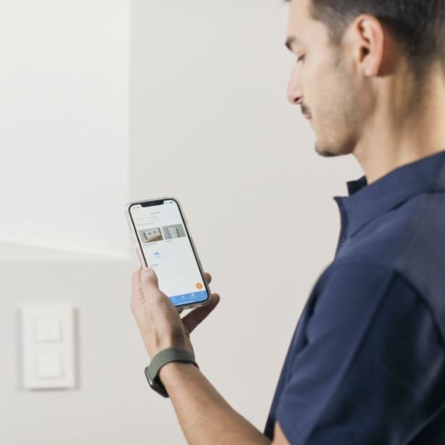 Mężczyzna korzystający z aplikacji dla instalatorów Hager Ready na swoim telefonie