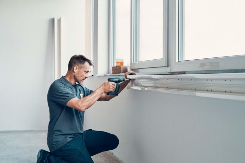 Mężczyzna instalujący kanał z rodziny BR firmy Hager