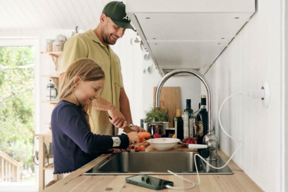 Mężczyzna i dziecko przygotowujący posiłek w kuchni, do kontaktu podłączone jest urządzenie elektryczne