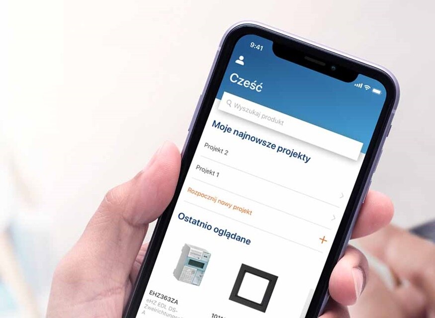 Osoba trzymająca smartfon z aplikacją do zarządzania projektami elektrycznymi na ekranie, wyświetlająca wyłącznik nadprądowy w sekcji ostatnio oglądane