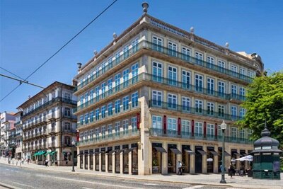 Arquitetura tradicional em Lisboa com linhas de bonde e céu azul límpido