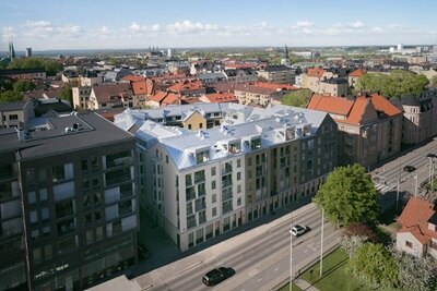 Flygbild över urbant landskap med byggnader som är utrustade med solpaneler på taken för hållbar energi