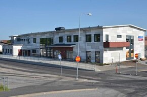 Modernt kommersiellt byggnadsexteriör med gatlyktor och klarblå himmel