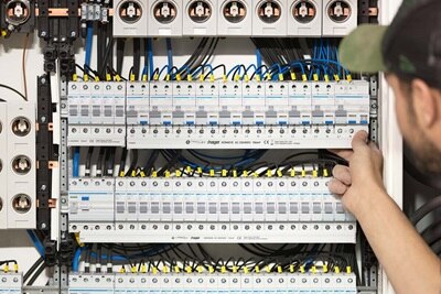 Tekniker arbetar på Hager säkringstavla med trådbundna anslutningar